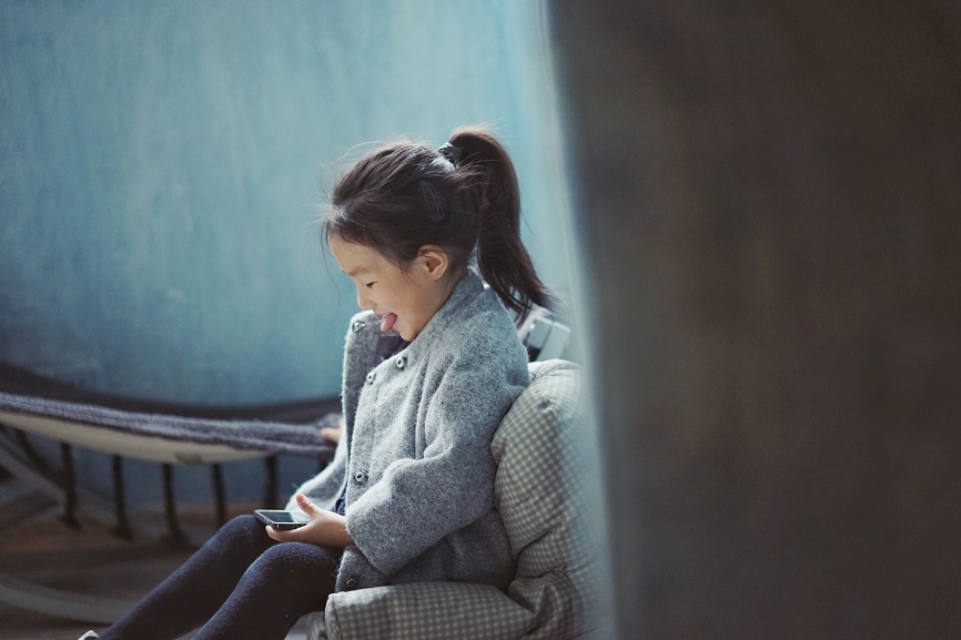 little girl smiling at phone
