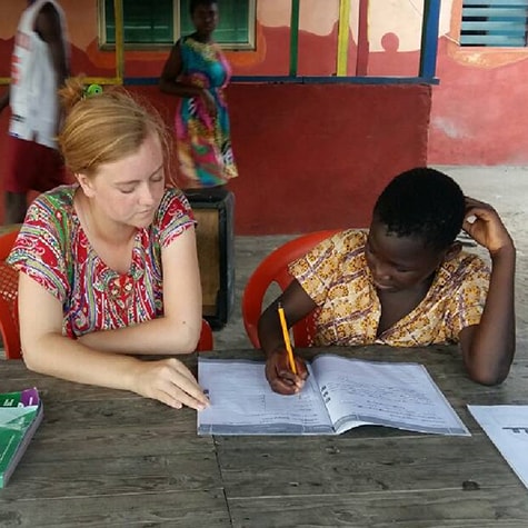 Volunteer teaching child Ghana